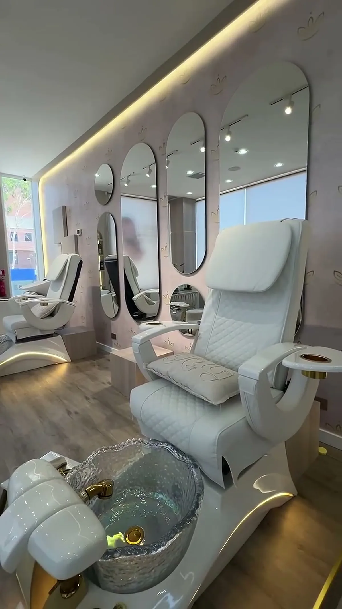 Sillones de pedicura con base dorada y pileta iluminada